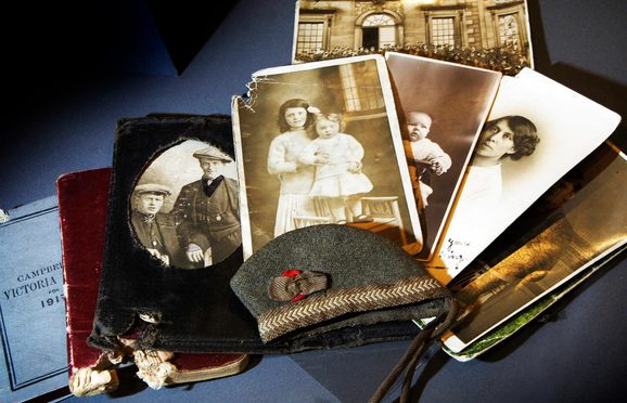 A selection of black and white portrait photographs lying on top of notebooks.
