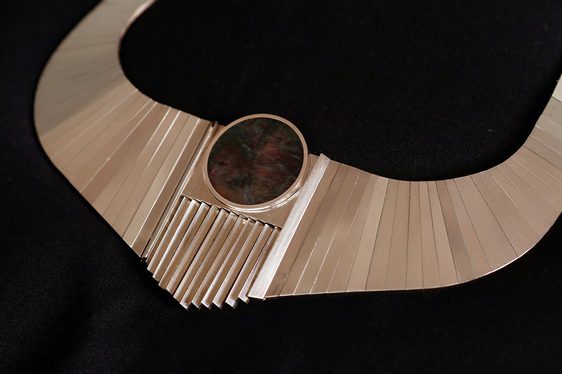 Close up of a gold necklace inset with a large red stone.