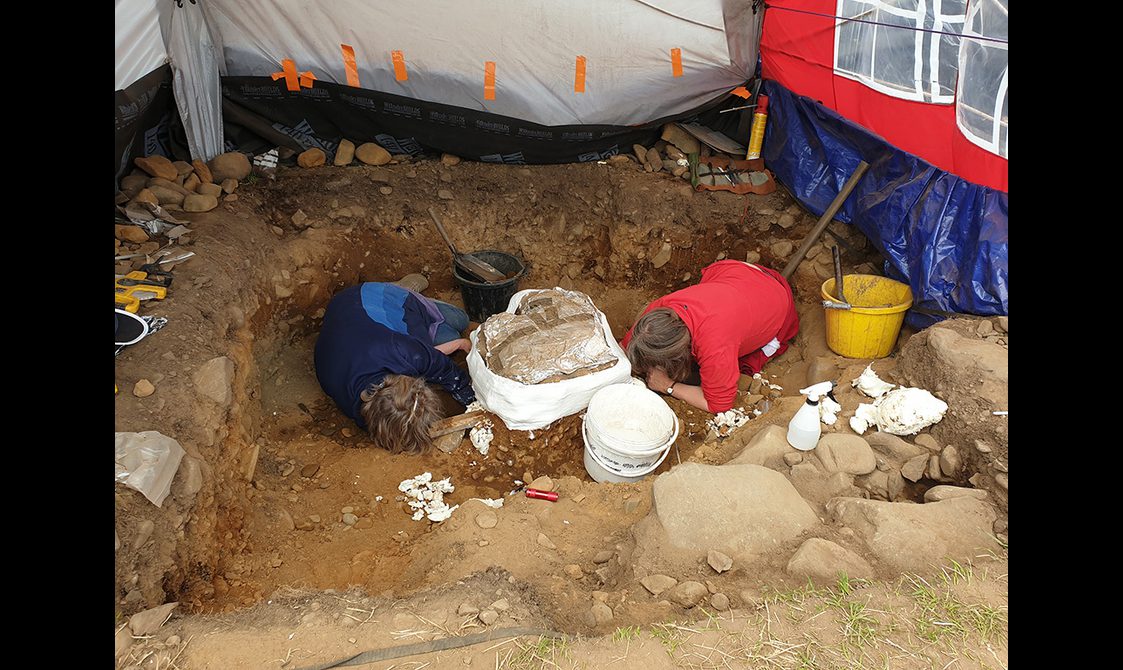 Curators working on the ground excavating the Peebles Hoard. The majority of the hoard has been wrapped and prepared to be block lifted from the site.