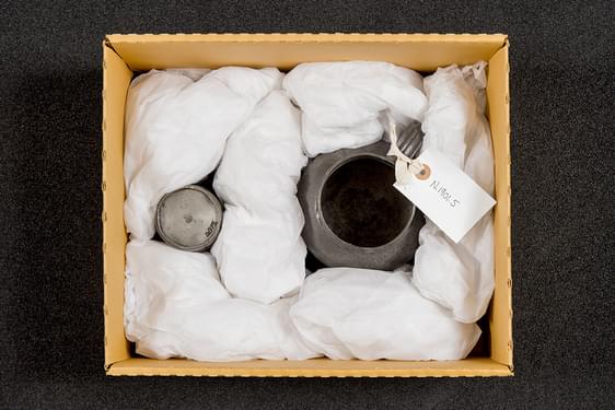 Two metal objects packed in a cardboard box.