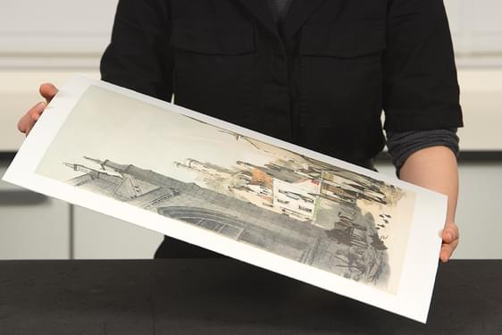 A curator holding an unframed artwork