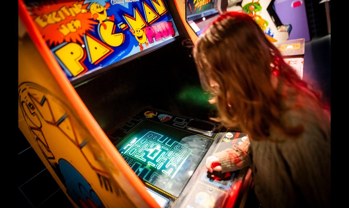 The arcade game PacMan is being played in the Game On exhibition