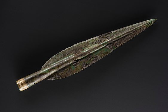 A Bronze Age spearhead. The base of the spearhead has a delicate gold hatched design.
