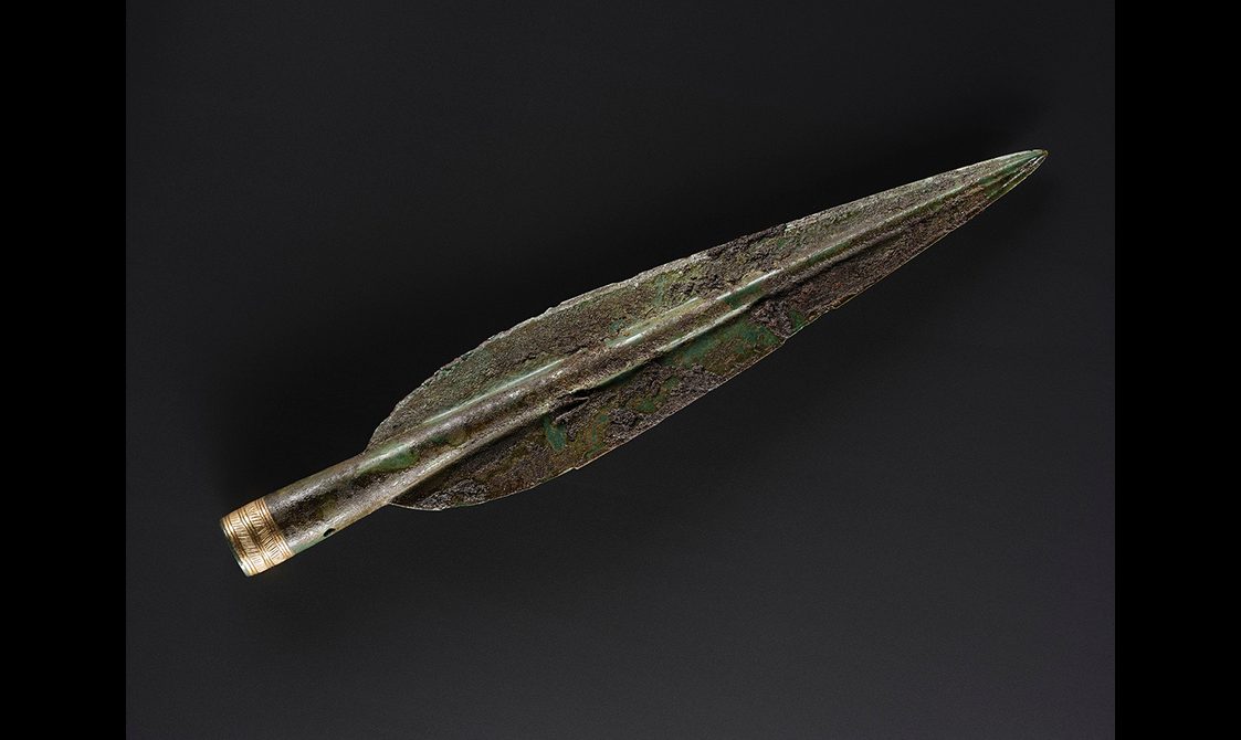 A Bronze Age spearhead. The base of the spearhead has a delicate gold hatched design.