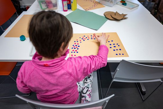 A child paints at a table