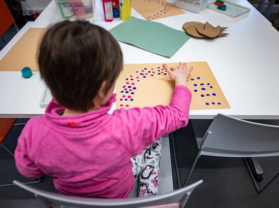 A child paints at a table