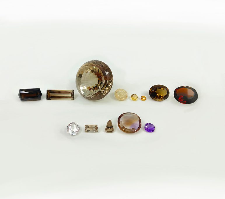 13 faceted clear gem stones varying from deep smoky brown to yellow, clear and purple