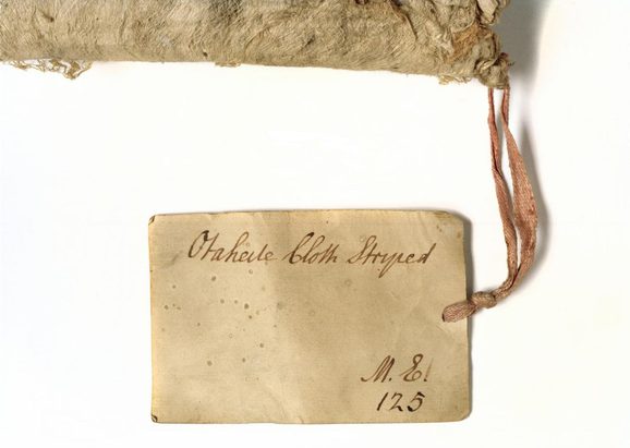 An old label attached to barkcloth showing the original number in the University Collection