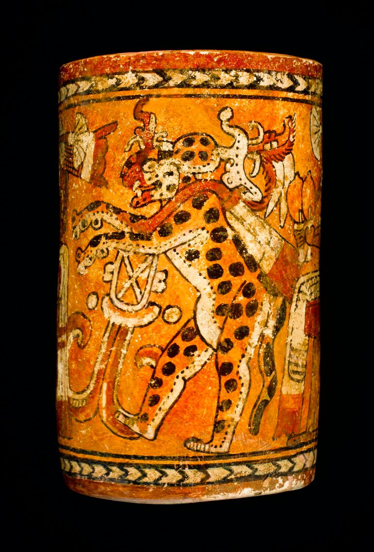 Ancient Mayan vase featuring a painted jaguar and elaborate decorative patterns, set against a black background.