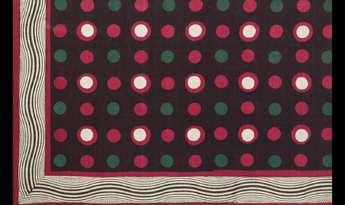 A wavy L shaped pattern runs from top left corner to bottom right, with green and red polka dots set against black background