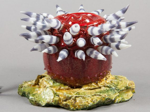 A restored model of a sea anemone made of red and grey glass