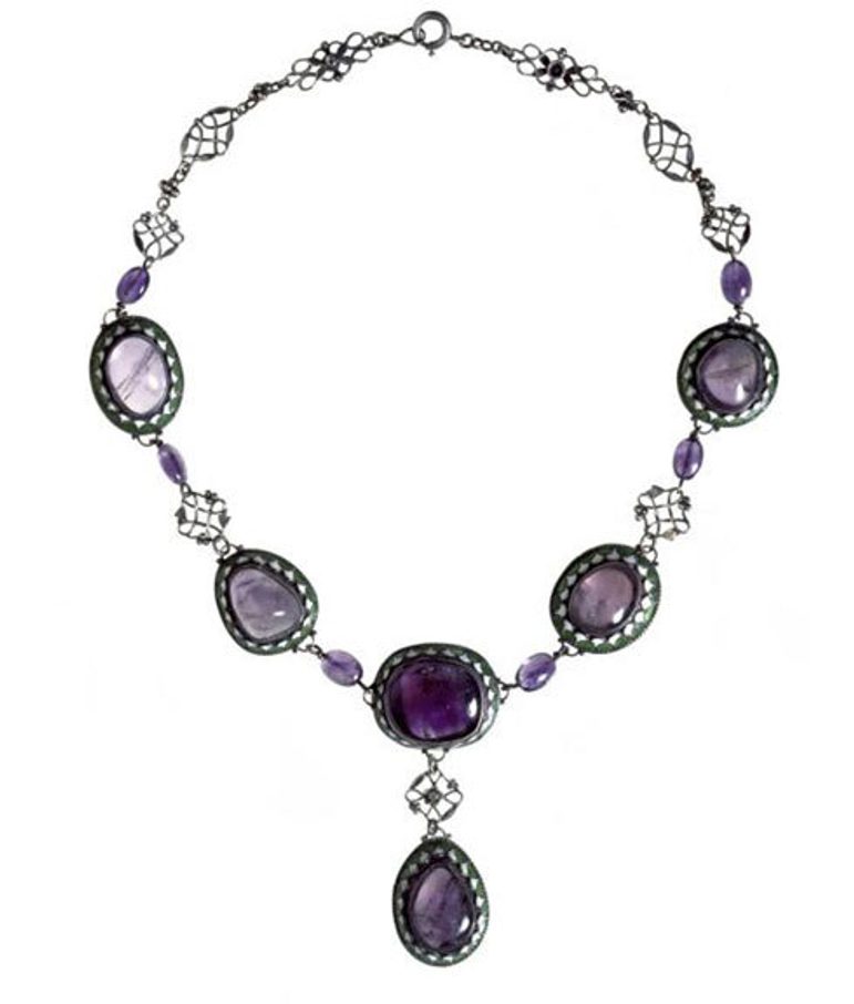 Art Deco style necklace with five purple coloured gemss set in oval green and white enamel settings arranged in a V shape. One gem in a shape of a drop is set off the five gems.