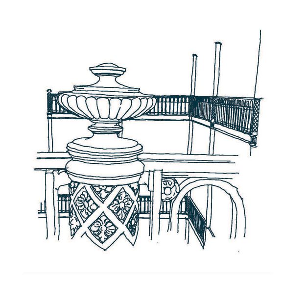 A green line illustrating of pillar with ornate floral and foliage designs.