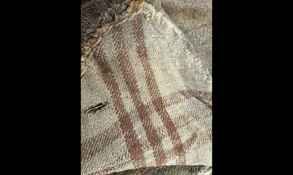 18th century menswear jacket inside with plaid fabric revealing stitching
