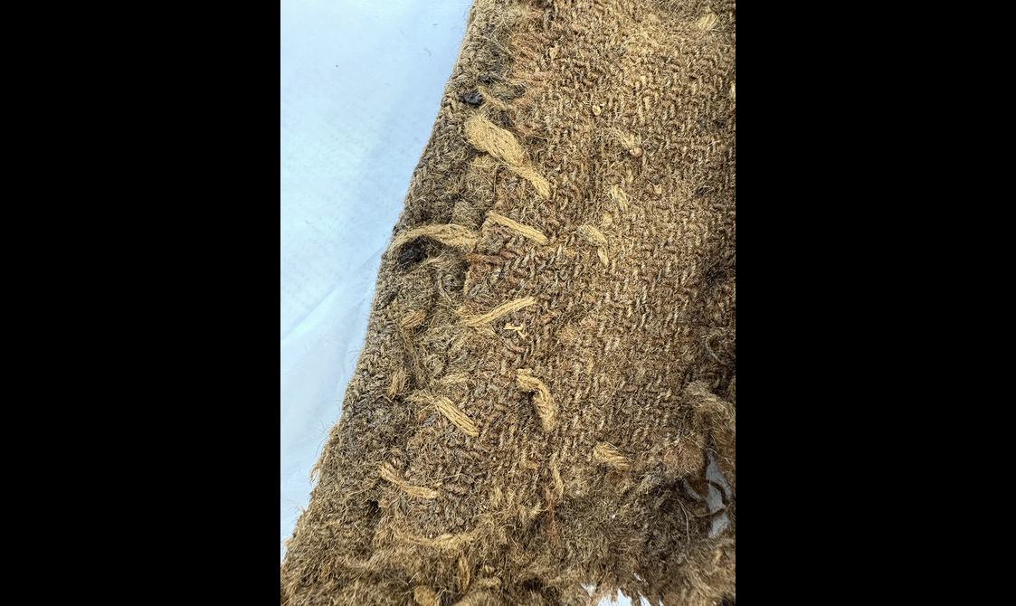 Fabric on 18th century menswear jacket inside showing repair stitching on seams.