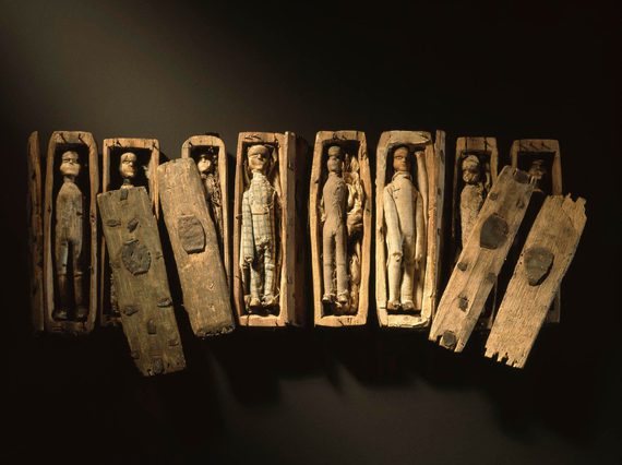 Set of miniature wooden coffins with wooden dolls inside.
