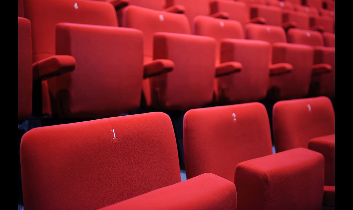 Rows of red seats in an auditorium.
