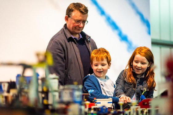 A parent and two children playing with lego bricks at the National Museum of Flight