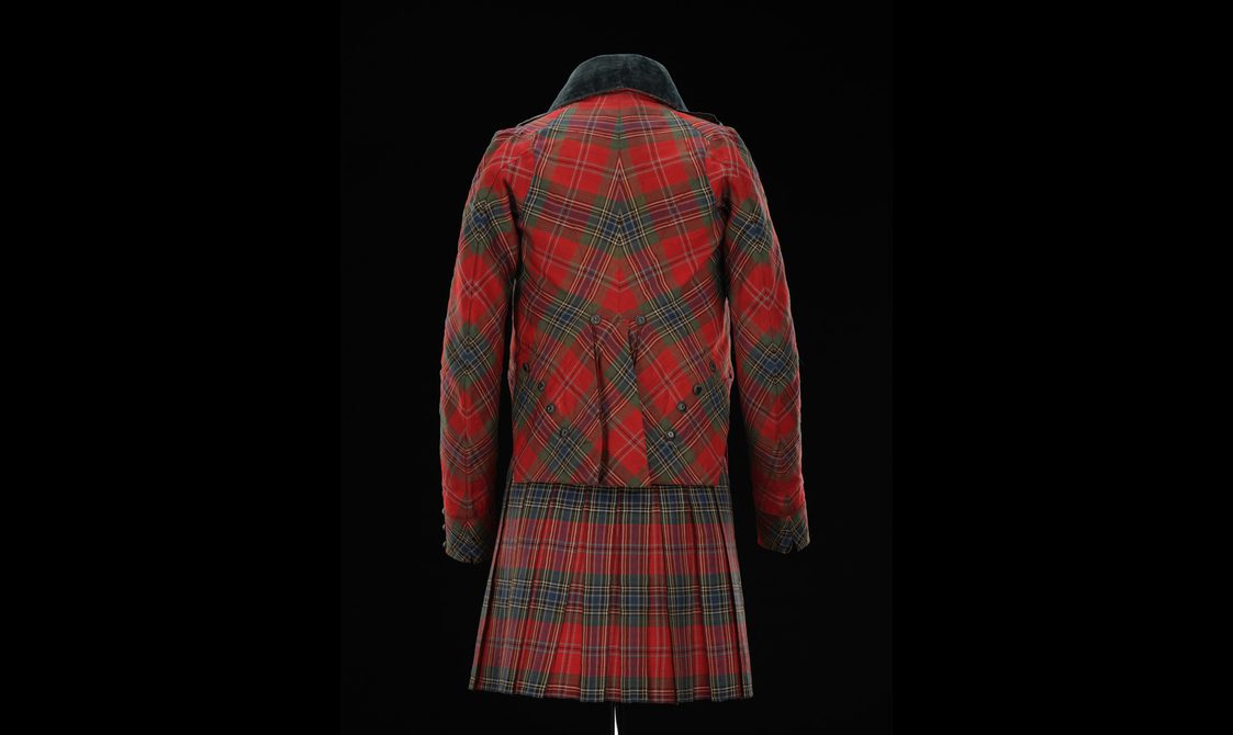back view of a mannequin wearing a red tartan kilt with a matching jacket.