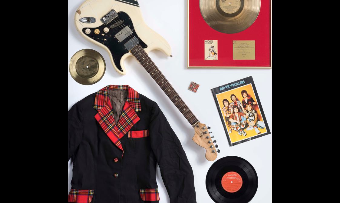 Objects that belonged to the Bay City Rollers, including vinyl discs, a black jacket with red tartan trimming, and a tour programme.