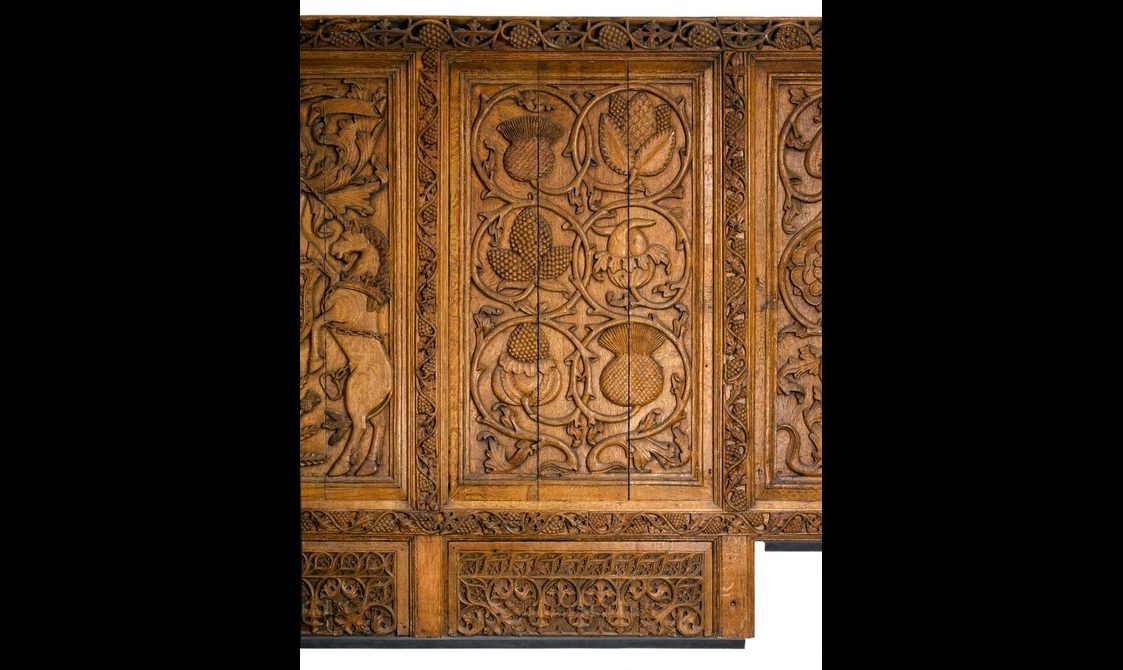 Carved oak panel depicting flowers and seedpods.
