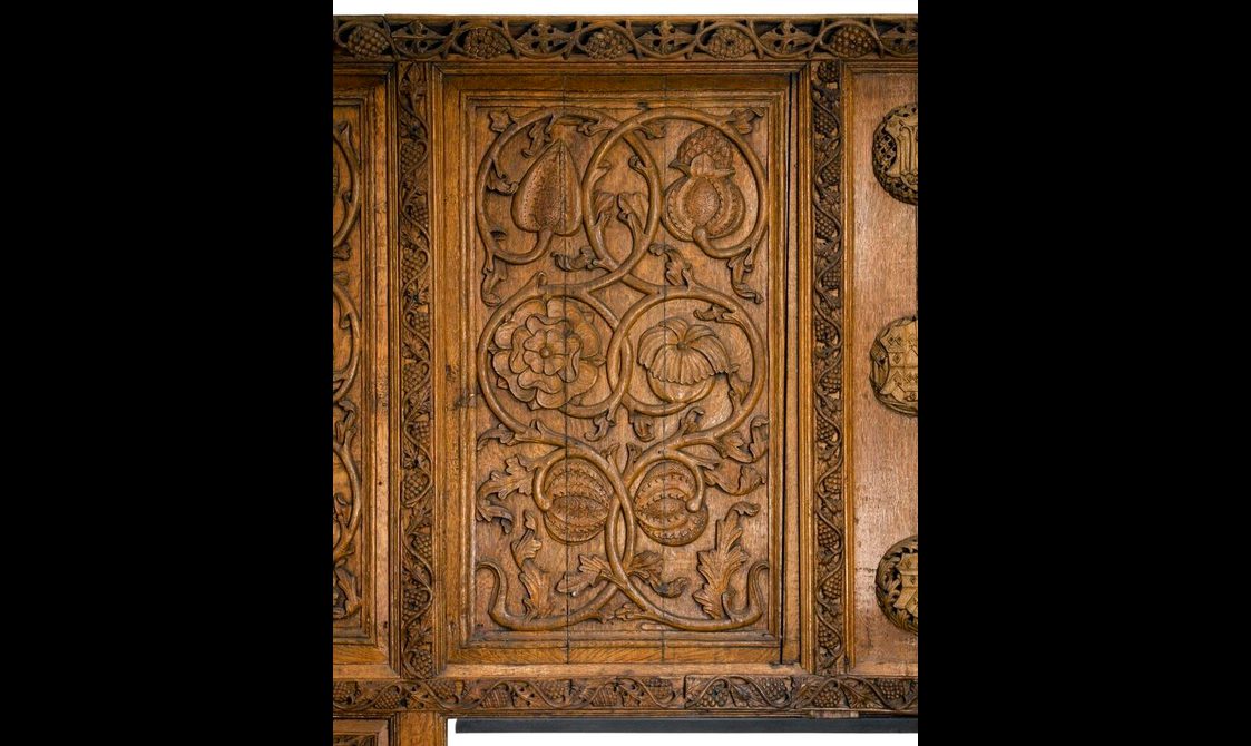 Carved oak panel depicting flowers and seedpods.