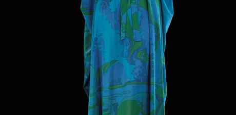 A mannequin wearing a blue kaftan with green and navy patterns.