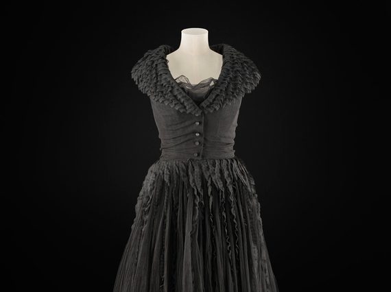 A knee length black dress on a torso mannequin