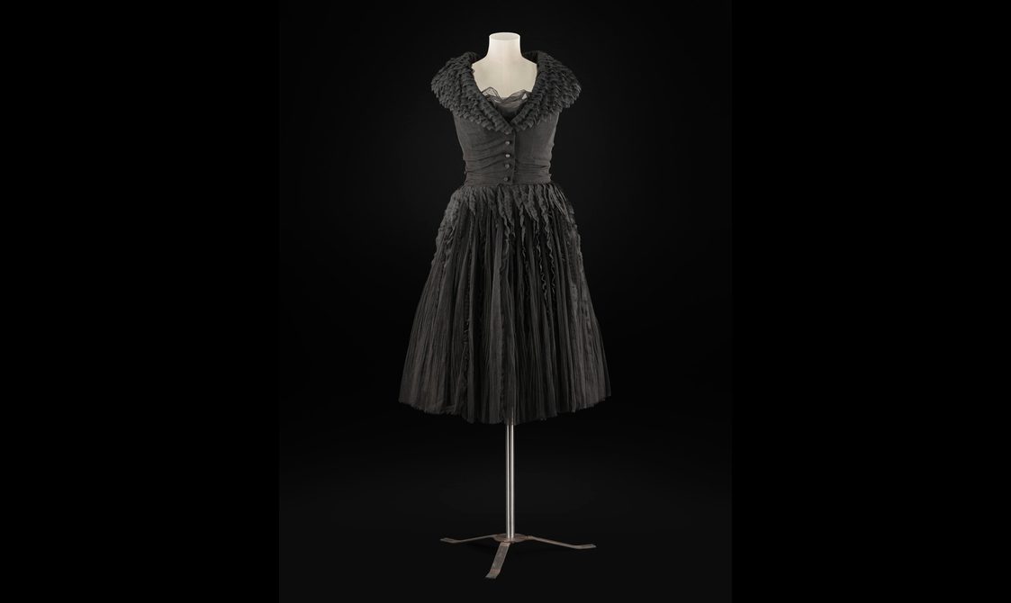 A knee length black dress on a torso mannequin