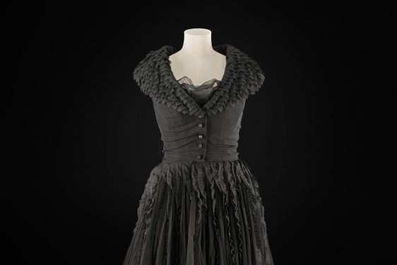 A knee length black dress on a torso mannequin