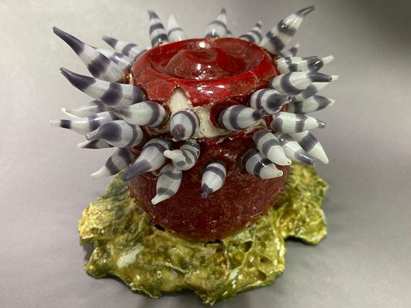 A glass model of a sea anemone is being reconstructed