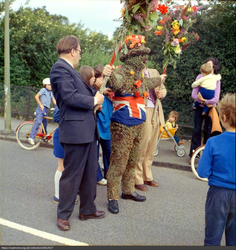 The Burry Man - a man covered head to tow in green burrs - being paraded through the town. He has a union flag tied round his waist and a hat made of burrs and flowers