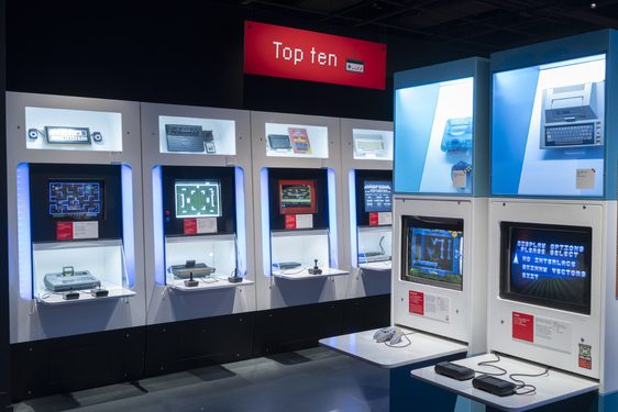 Playable games in the Game On exhibition, which look like a series of computers with different consoles attached. A sign above them says 'Top Ten'.