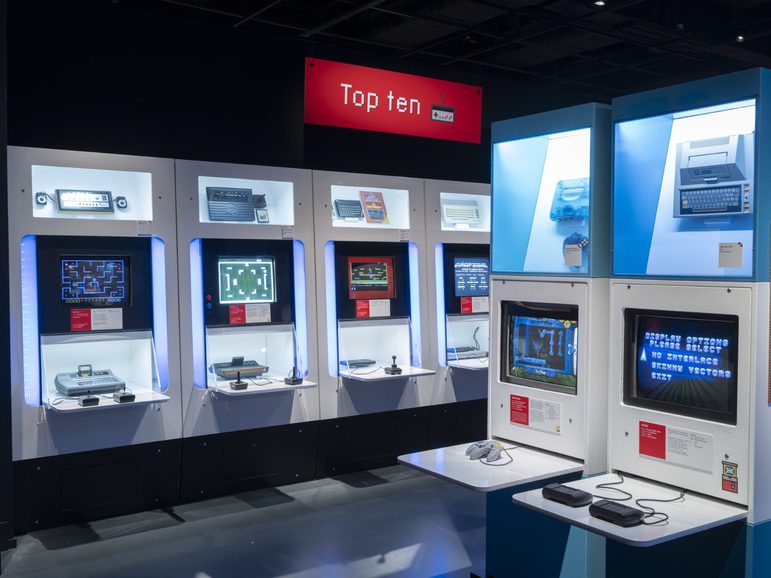 Playable games in the Game On exhibition, which look like a series of computers with different consoles attached. A sign above them says 'Top Ten'.