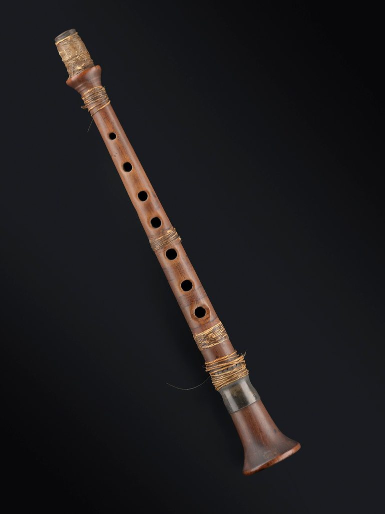 A wooden instrument that looks like a pipe with finger holes in, that the musician blows into from the top.