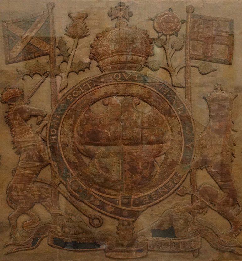 A brownish banner depicting a royal crest