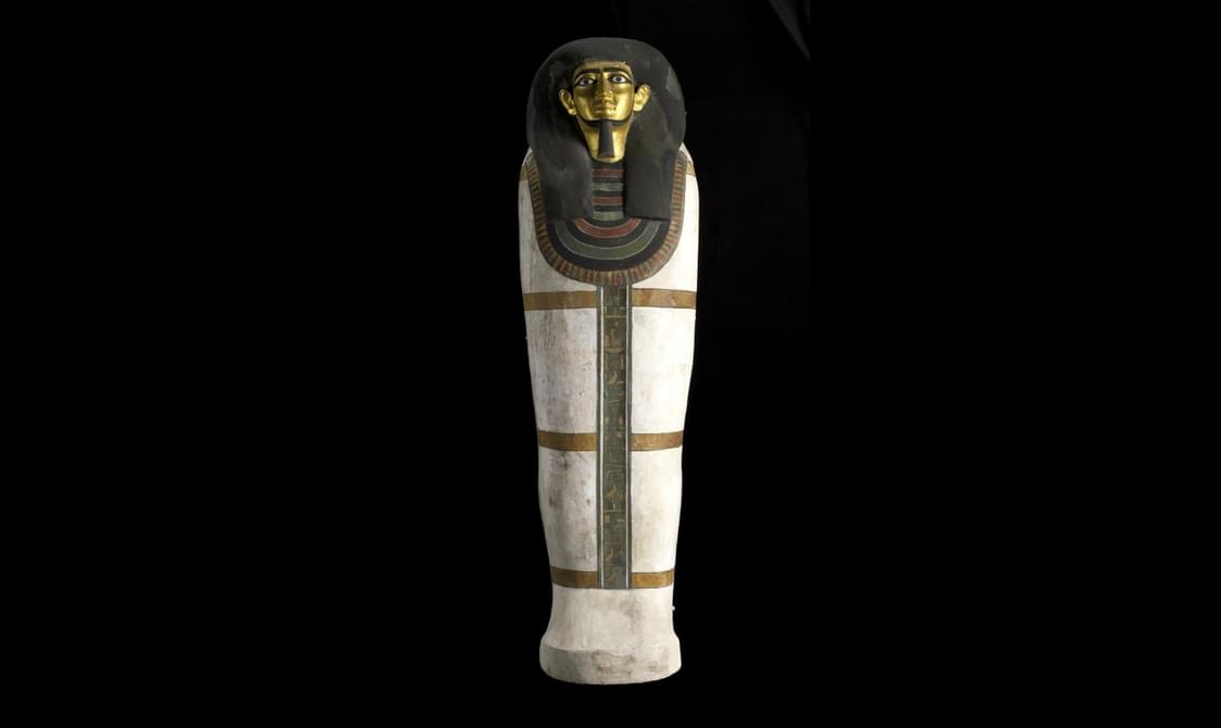 An Egyptian coffin painted white, with four gold bands with black edging encircling the lid and base. The lid shows a man with a black-painted wig, gilded face, black-painted eyebrows and inlaid-stone eyes.