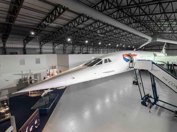 A view of the Concorde plane inside a hangar with its stairway doors open.
