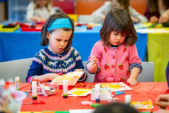 Two children doing crafts at a table.