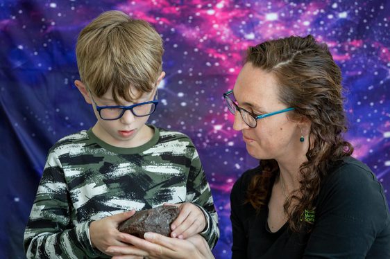 A child and adult looking at a geological specimen.