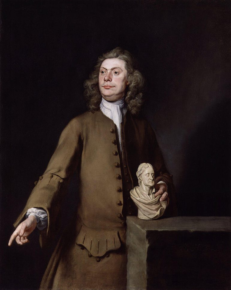 A painting of a man with shoulder length curly hair wearing a brown jacket and brown bottoms with a high white collared shirt. The background is a dark brown and the man is pointing down with one hand and holding an ivory bust of a man in the other hand.