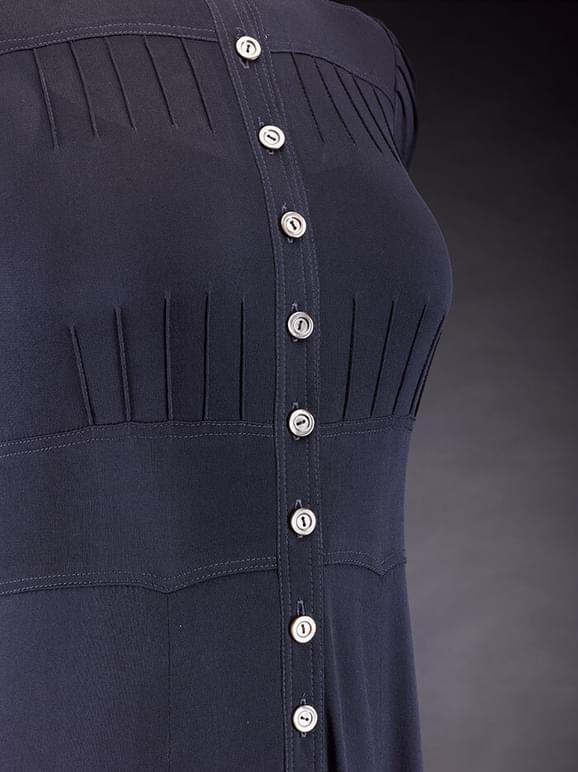 Detail of a navy dress with mother of pearl buttons down the front, and seaming detailing.