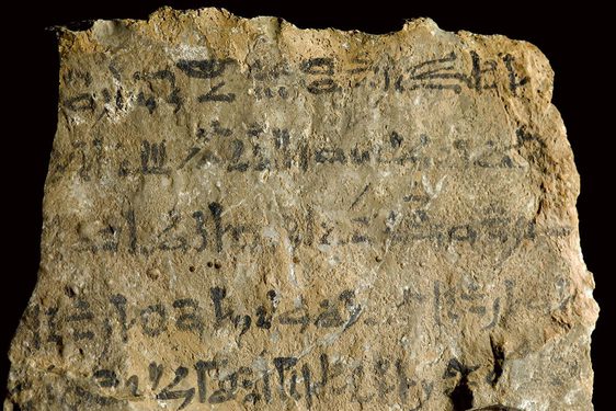 A yellowed stone with an inscription written in black ink.