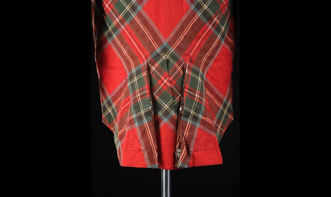 Detail of folds at the back of a red tartan jacket.