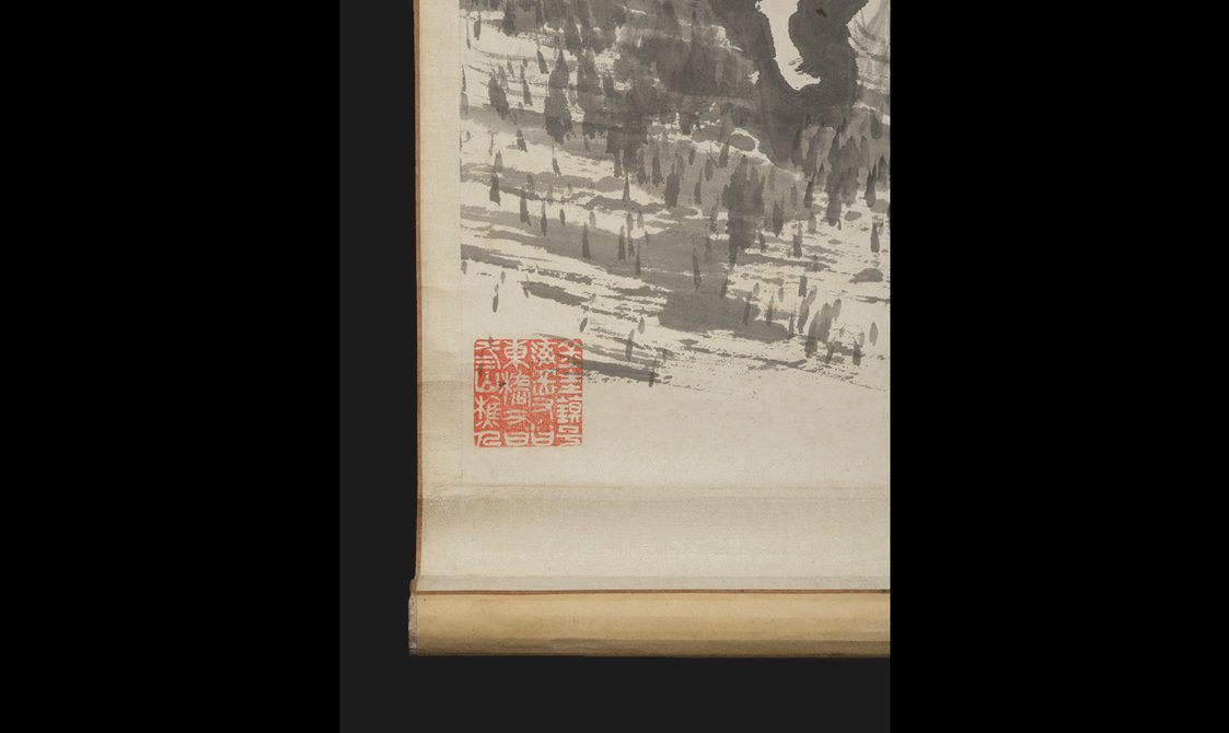 Detail of a hanging scroll painting with a red seal and landscape details.