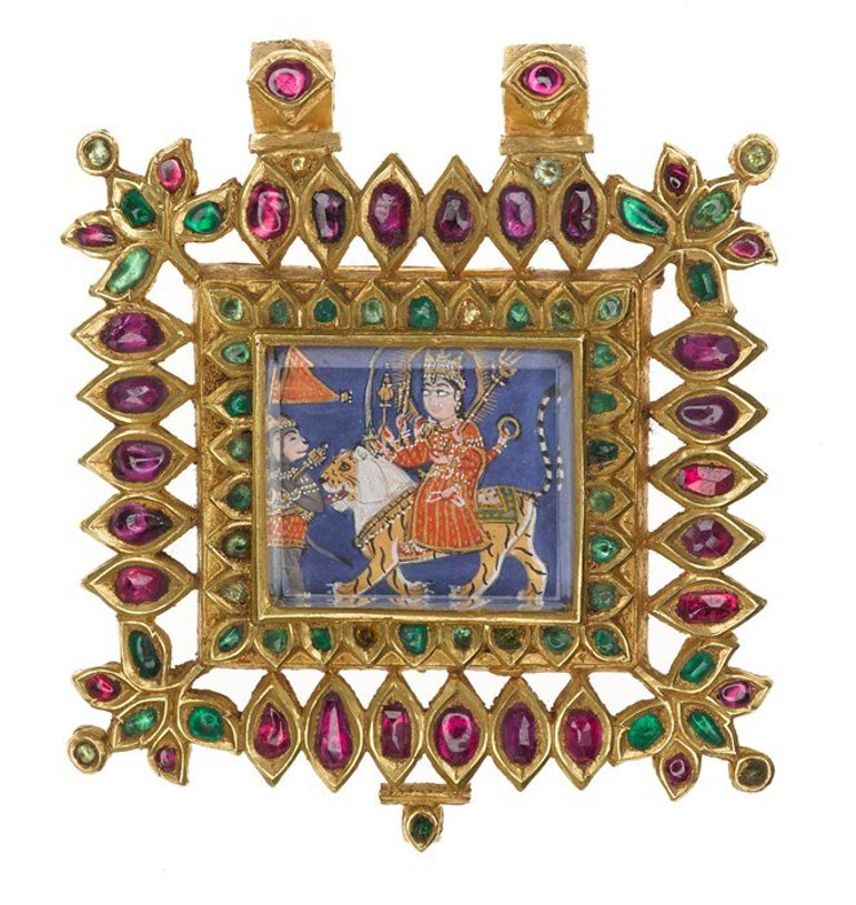 A square shaped pendant comprised of pink and green gems set into gold, with an inset that depicts a figure sat on a horse
