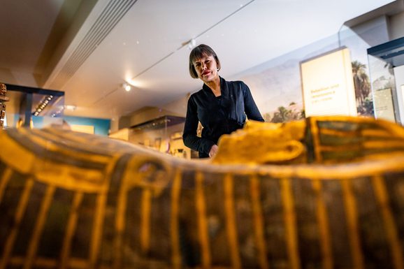 Visitor looking at a sarcophagus in the Ancient Egypt gallery.