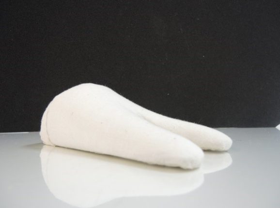 A white textile mount sitting on a white table with a black background.