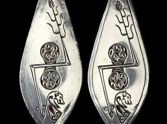 Leaf-shaped plaques of silver designed with Pictish symbols.