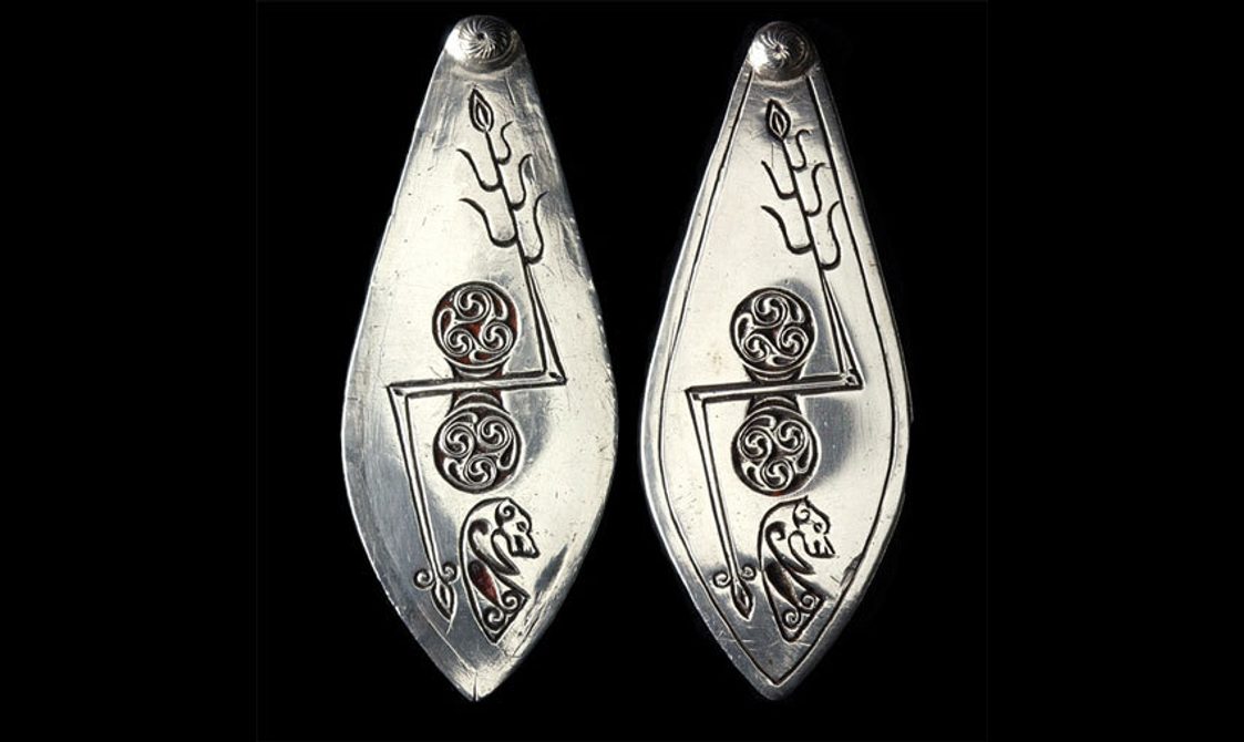 Leaf-shaped plaques of silver designed with Pictish symbols.